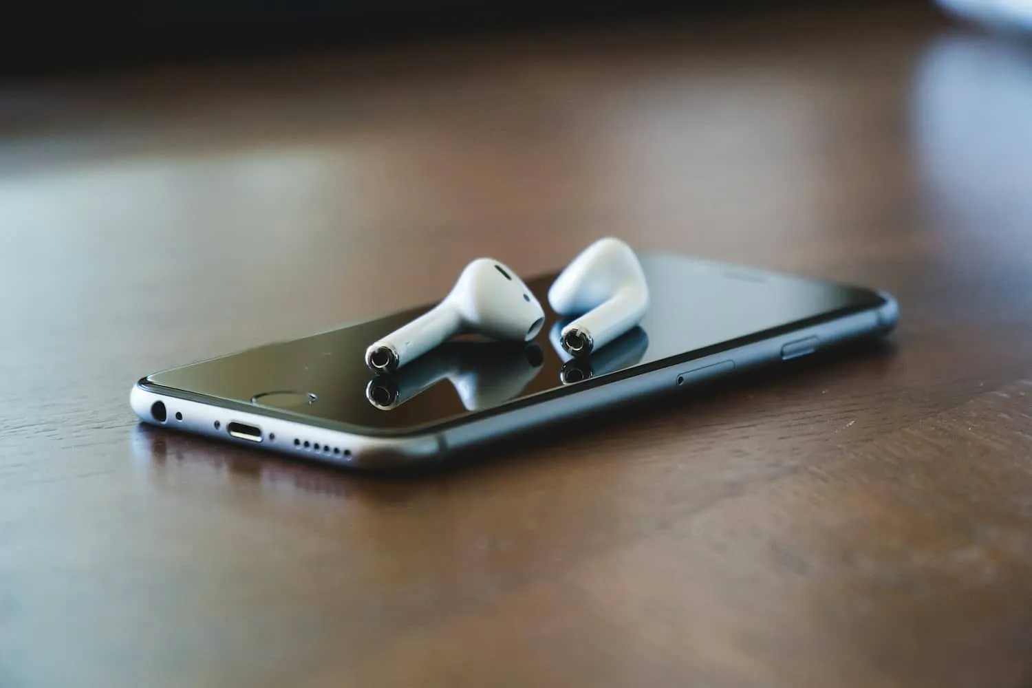 A phone and headphones resting on a desk