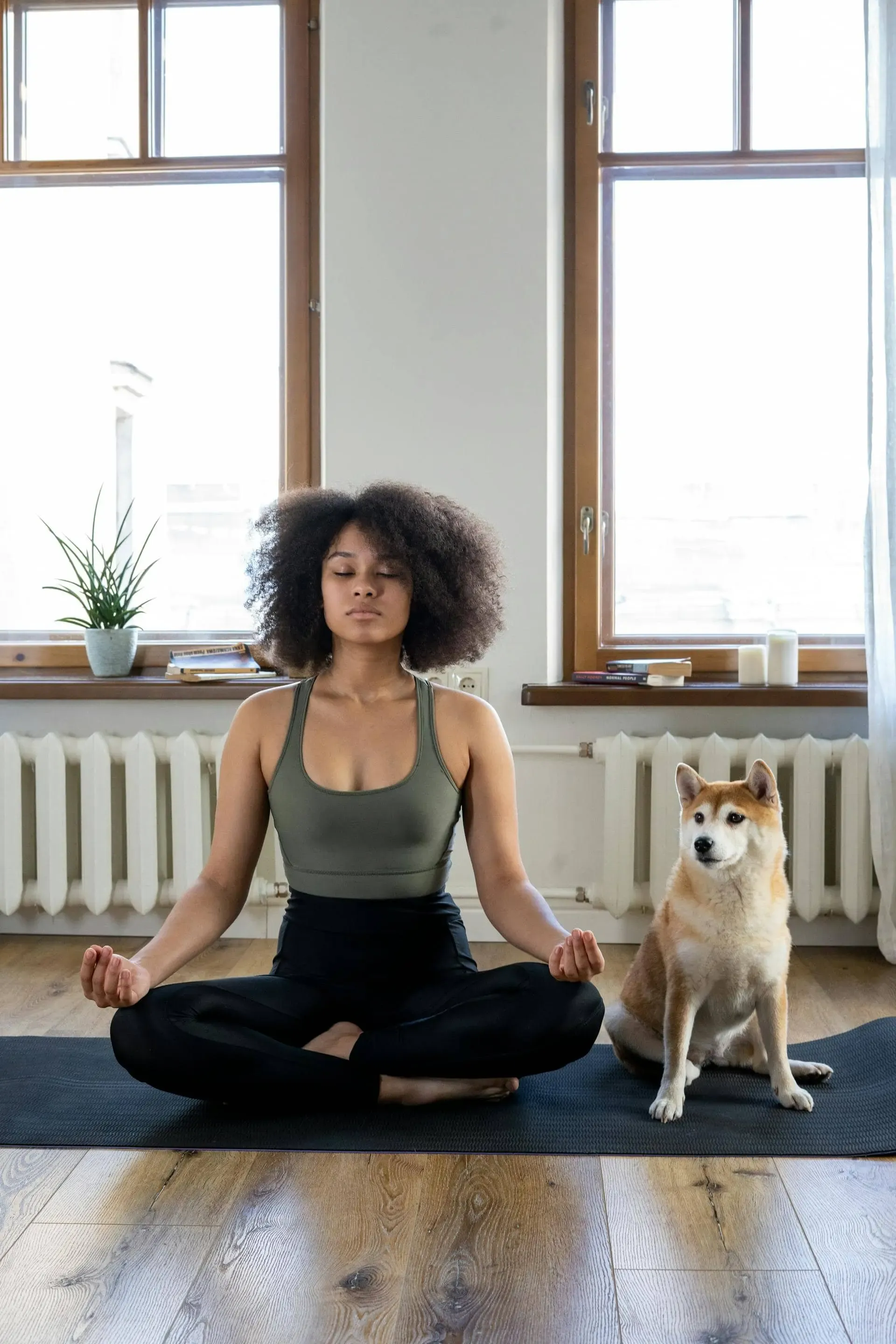 A person in athletic clothes practicing meditation at home